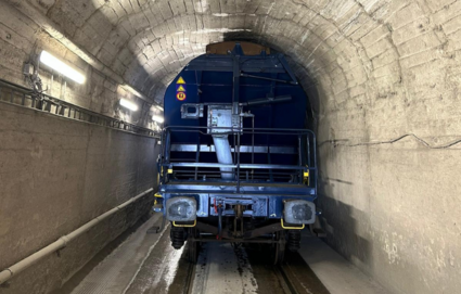 Hopperwagen durchfährt historischen Tunnel mit niedriger Deckenhöhe.